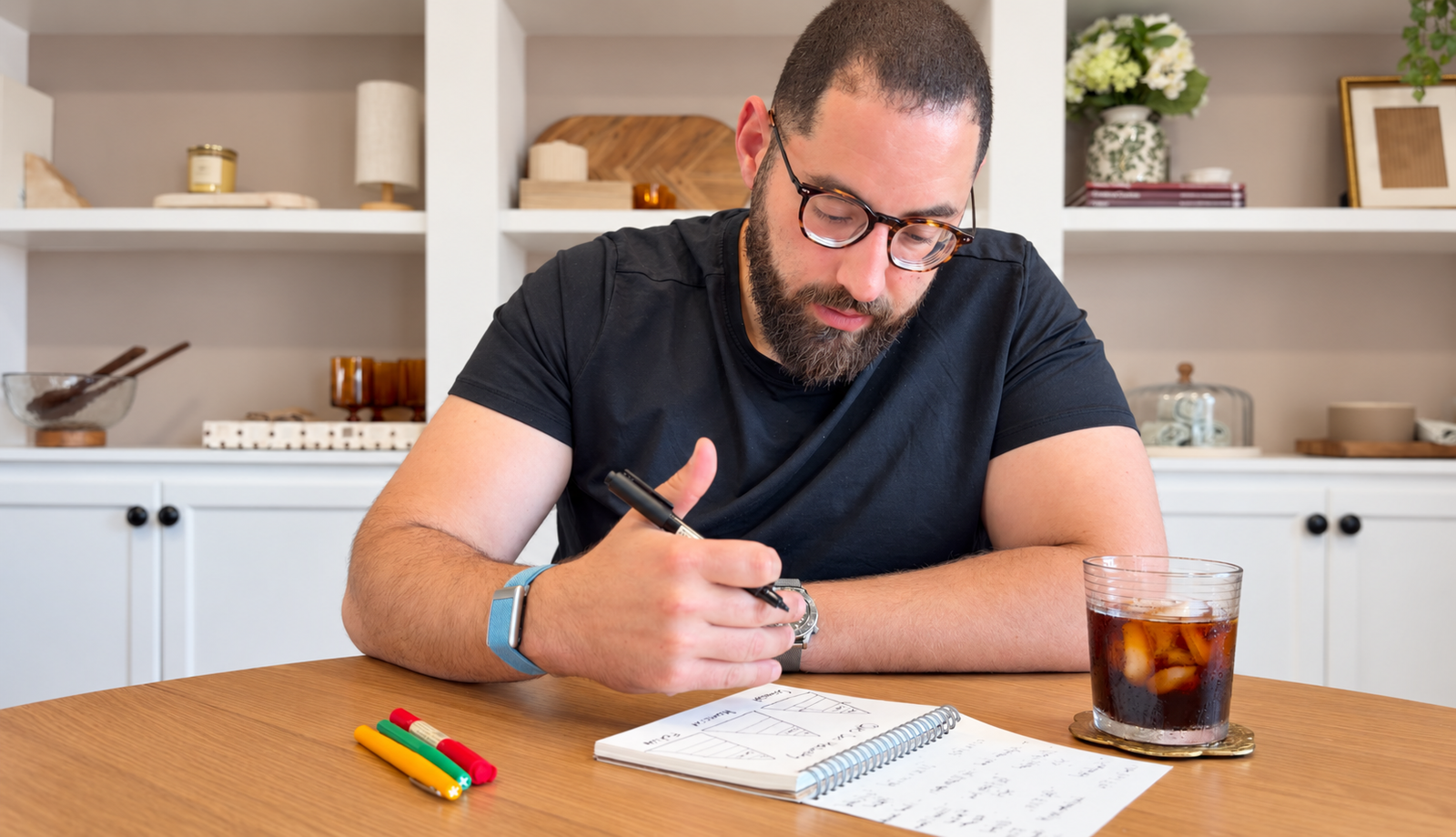 Subhi Saadeh writing in a notebook at a table.